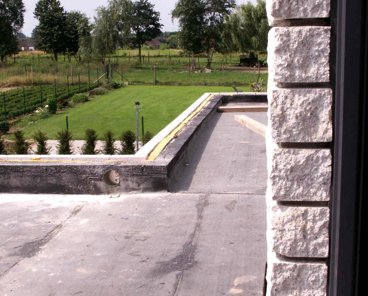 Black EPDM rubber membrane on a flat roof with seams running up to a low parapet wall